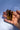 Three Tiger's eye crystal points held in a person's open hand against a blue sky background.